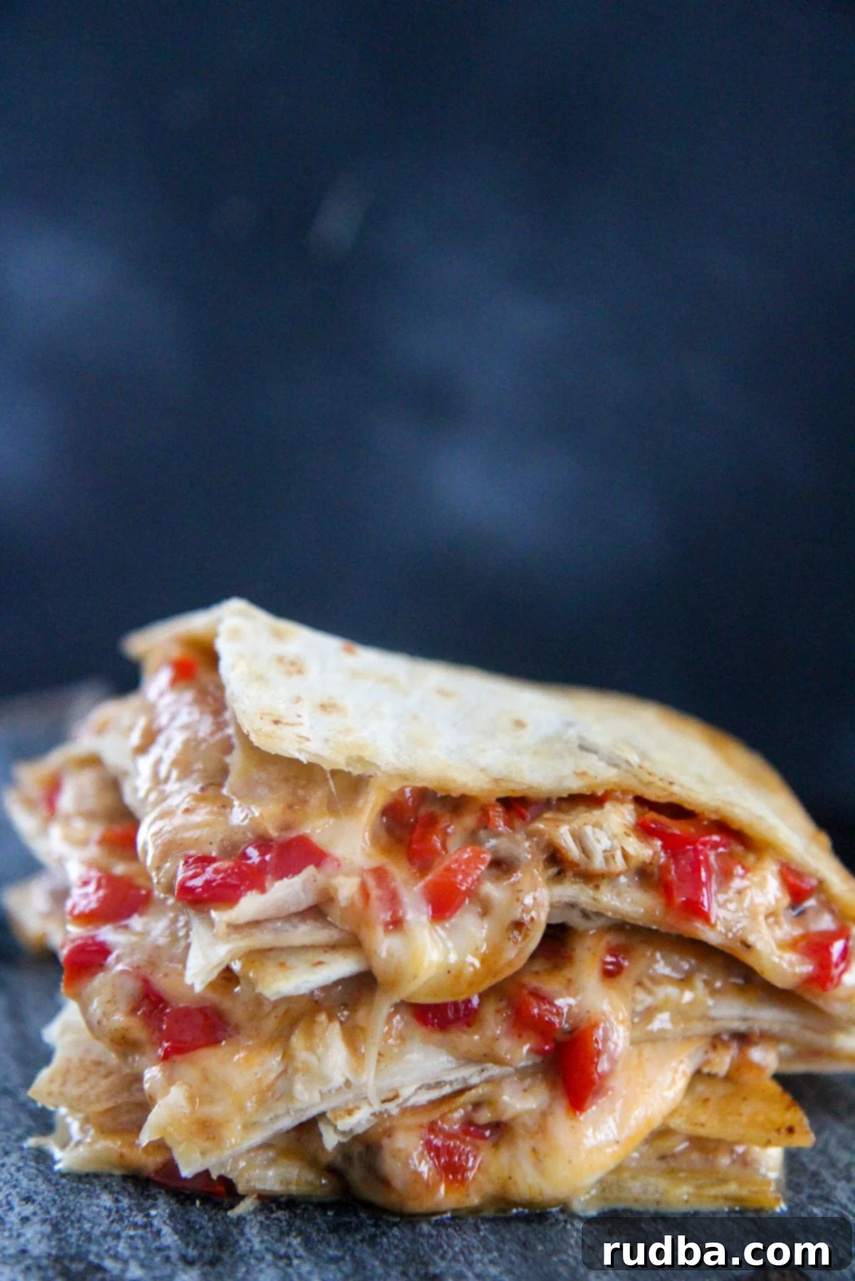 four cheesy chicken quesadillas stacked up close 