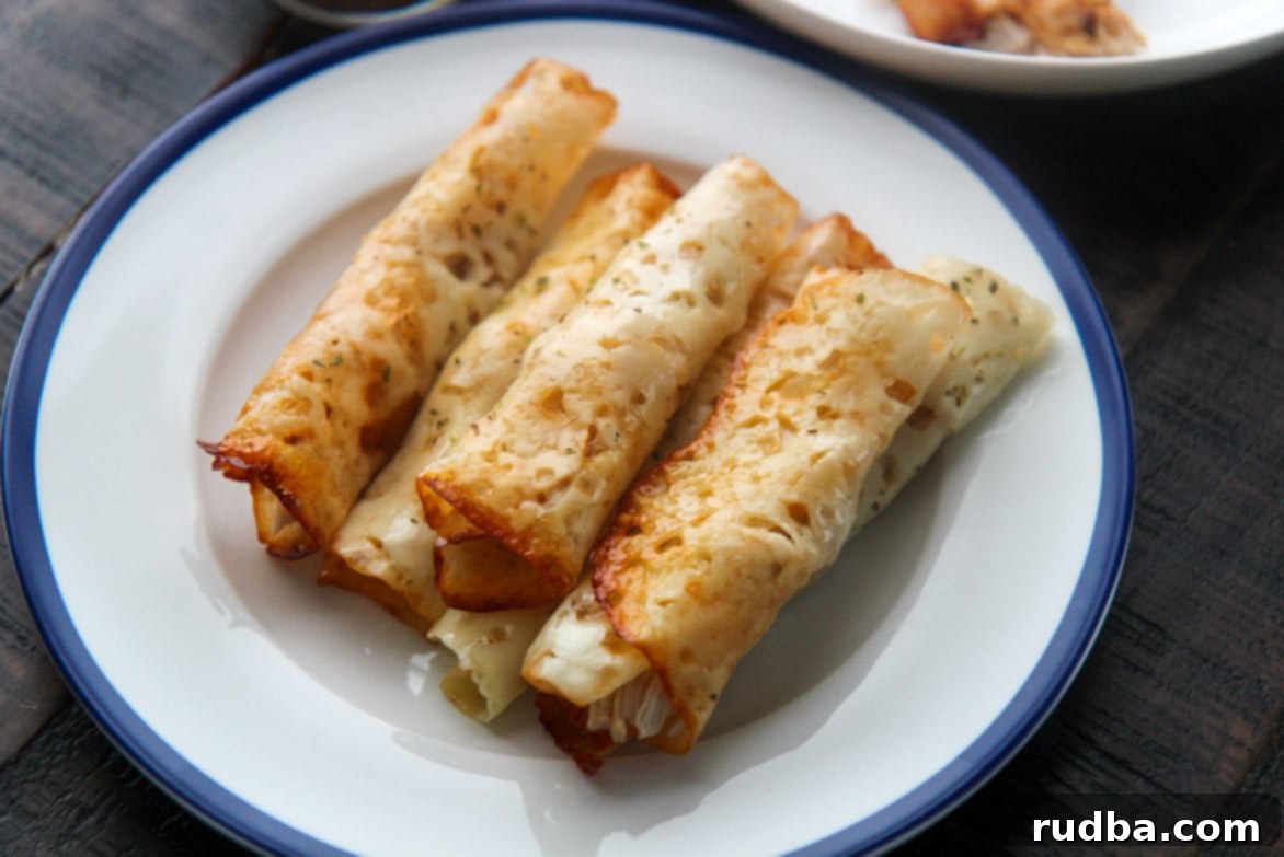 Several keto Cajun chicken taquitos served on a pristine white plate, garnished with fresh herbs, ready for a delicious low-carb meal.