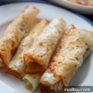 six keto cajun chicken taquitos on a white and blue plate