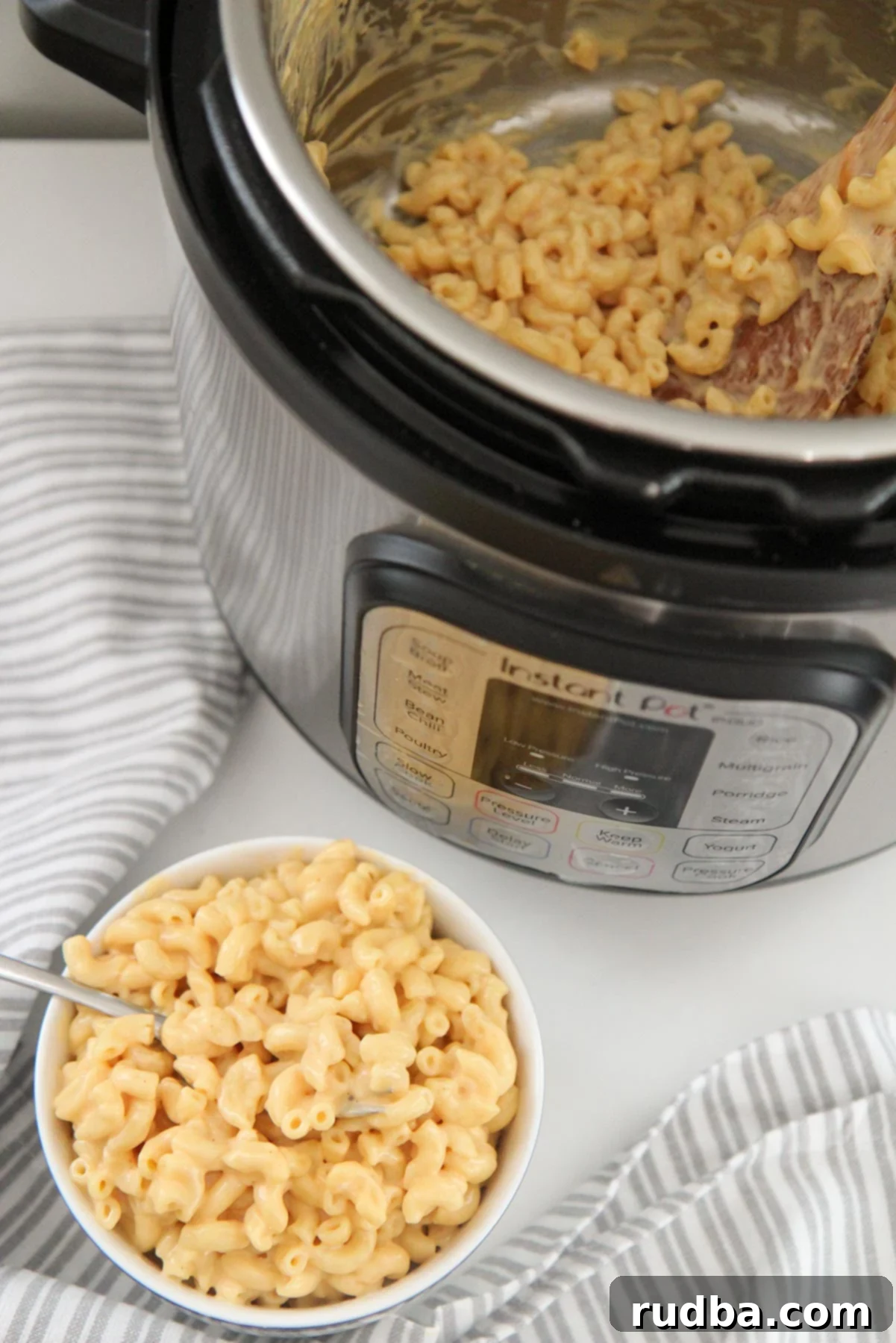 a small bowl filled with mac and cheese and an instant pot with mac and cheese in the background. 