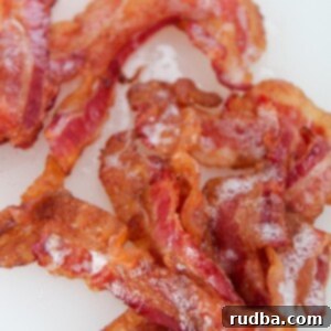 one pound of crispy bacon up close on a white chopping board.