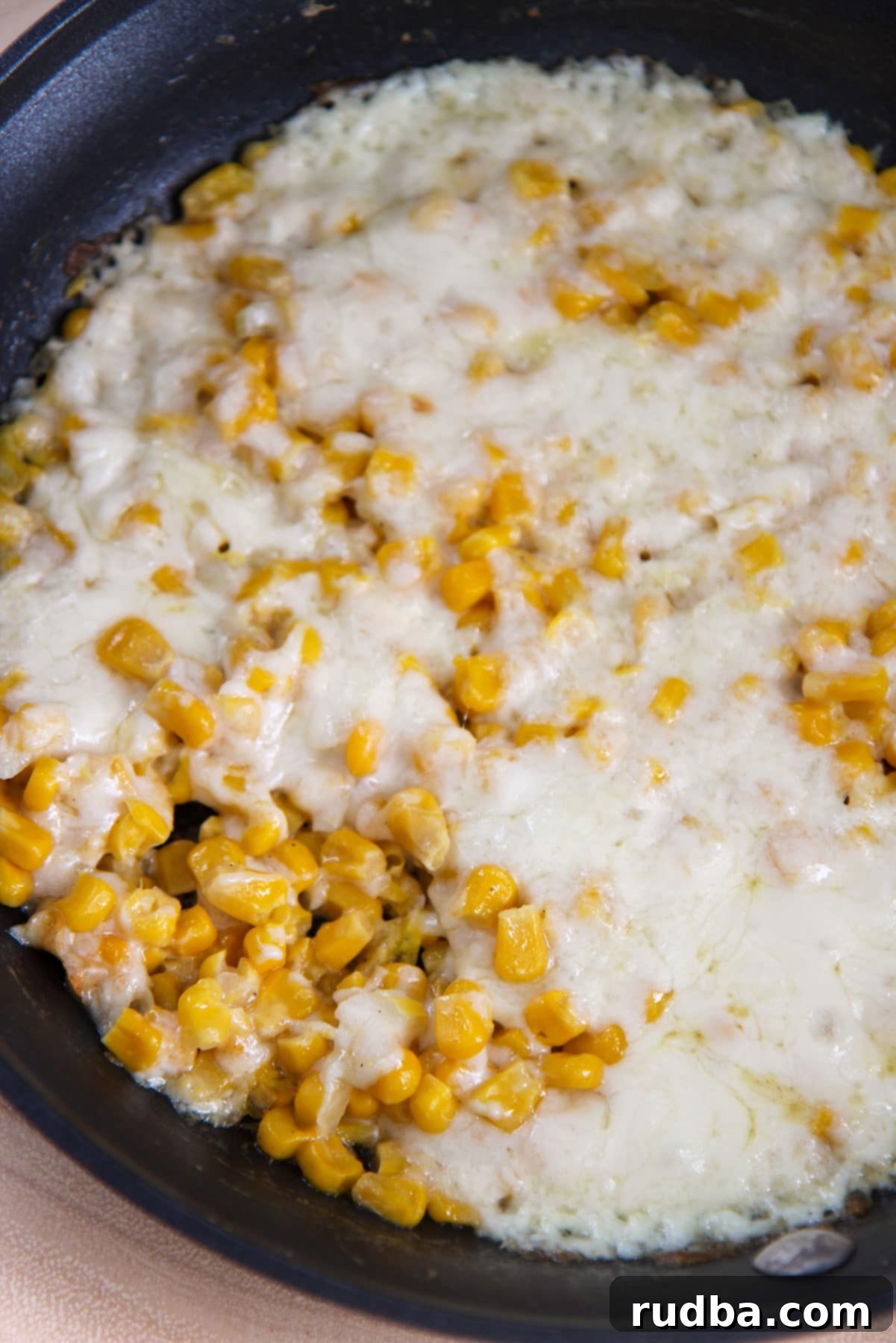 corn and cheese in a black skillet. 