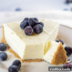 Effortless Creamy Cheesecake 6 A fork slicing into a creamy no-bake cheesecake.