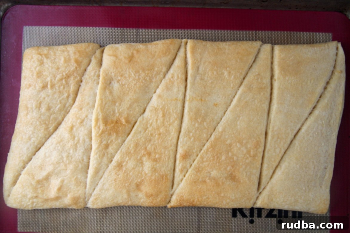 eight crescent rolls baked on a baking sheet.
