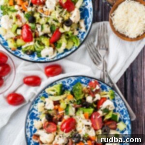 Zesty Garden Salad with Homemade Italian Dressing 8 two bowls filled with vegetable salad with homemade Italian dressing. Two forks on the side and parmesan cheese.