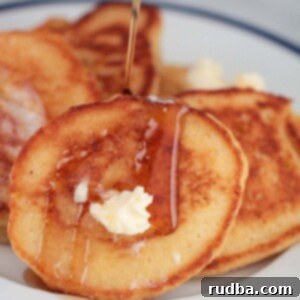 Golden Corn Cakes 2 hoe cakes with butter and syrup up close.