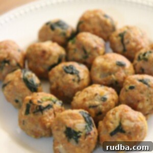 Flavorful Spinach Turkey Meatballs 4 Fifteen perfectly baked spinach and turkey meatballs on a white plate, ready to be served.