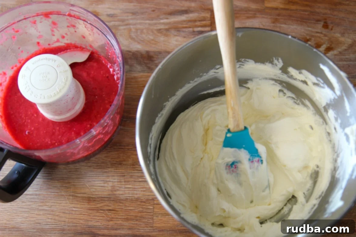 A close-up view of a bowl of freshly whipped cream and a food processor containing smooth raspberry puree, highlighting two key components for the tart filling.