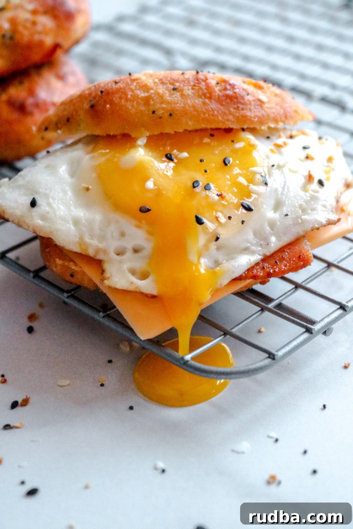 An up close shot of the keto breakfast sandwich with a runny egg on top of a wire rack.