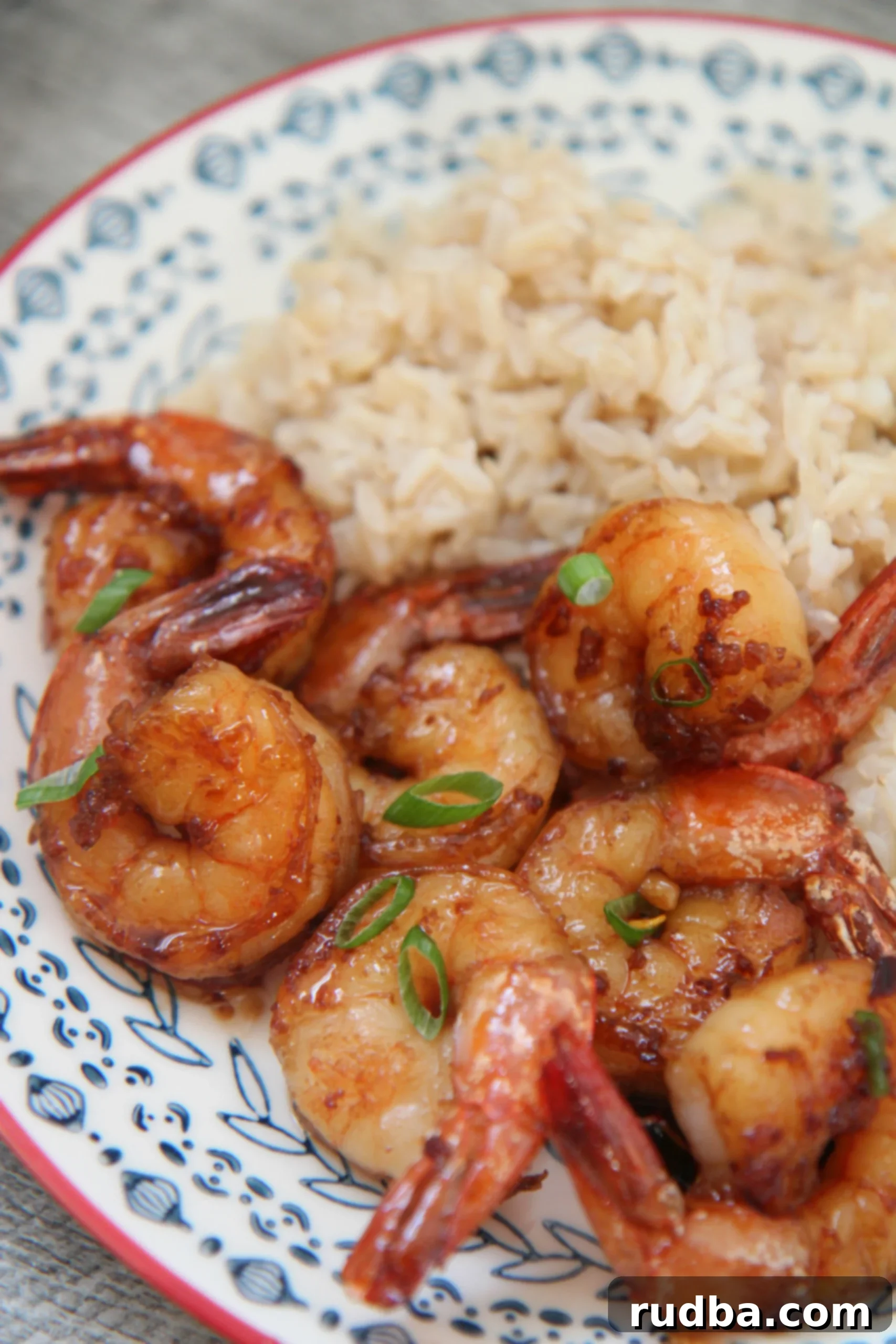 Honey garlic shrimp with fresh scallions and a side of brown rice, ready to be served.