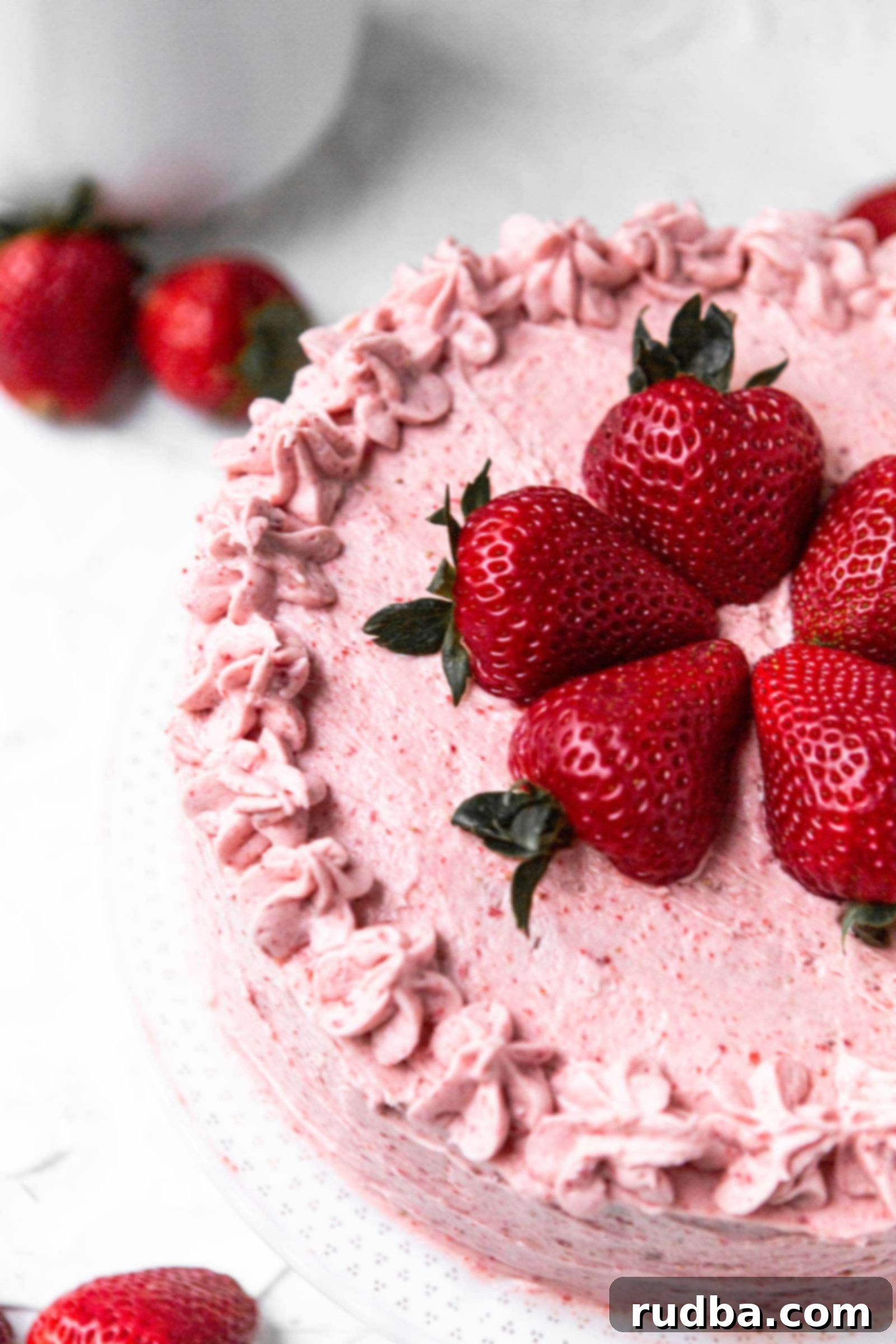 half of an entire strawberry cake with fresh strawberries on top and on the side. 