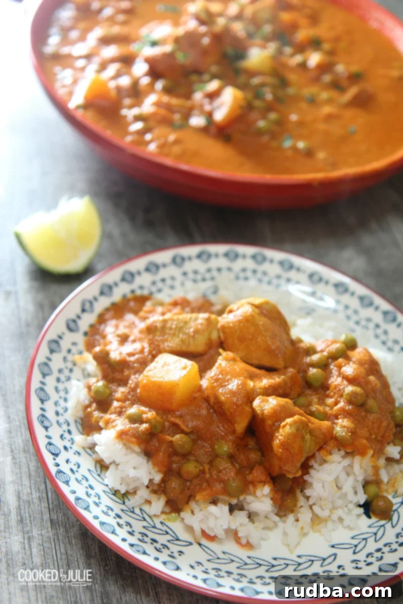 A vibrant bowl of coconut chicken curry served over white basmati rice, garnished with fresh cilantro, ready to be enjoyed.