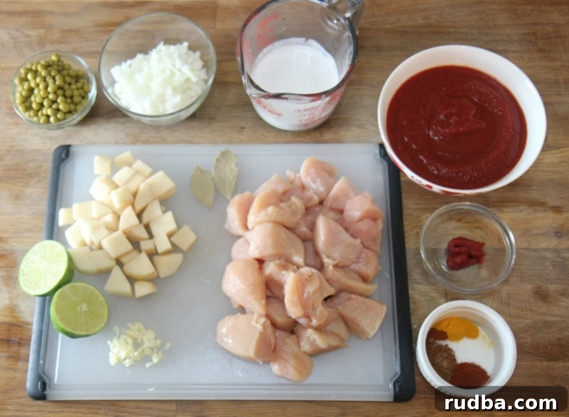 A selection of fresh ingredients including onions, garlic, potatoes, and spices laid out on a wooden cutting board, ready for prep.
