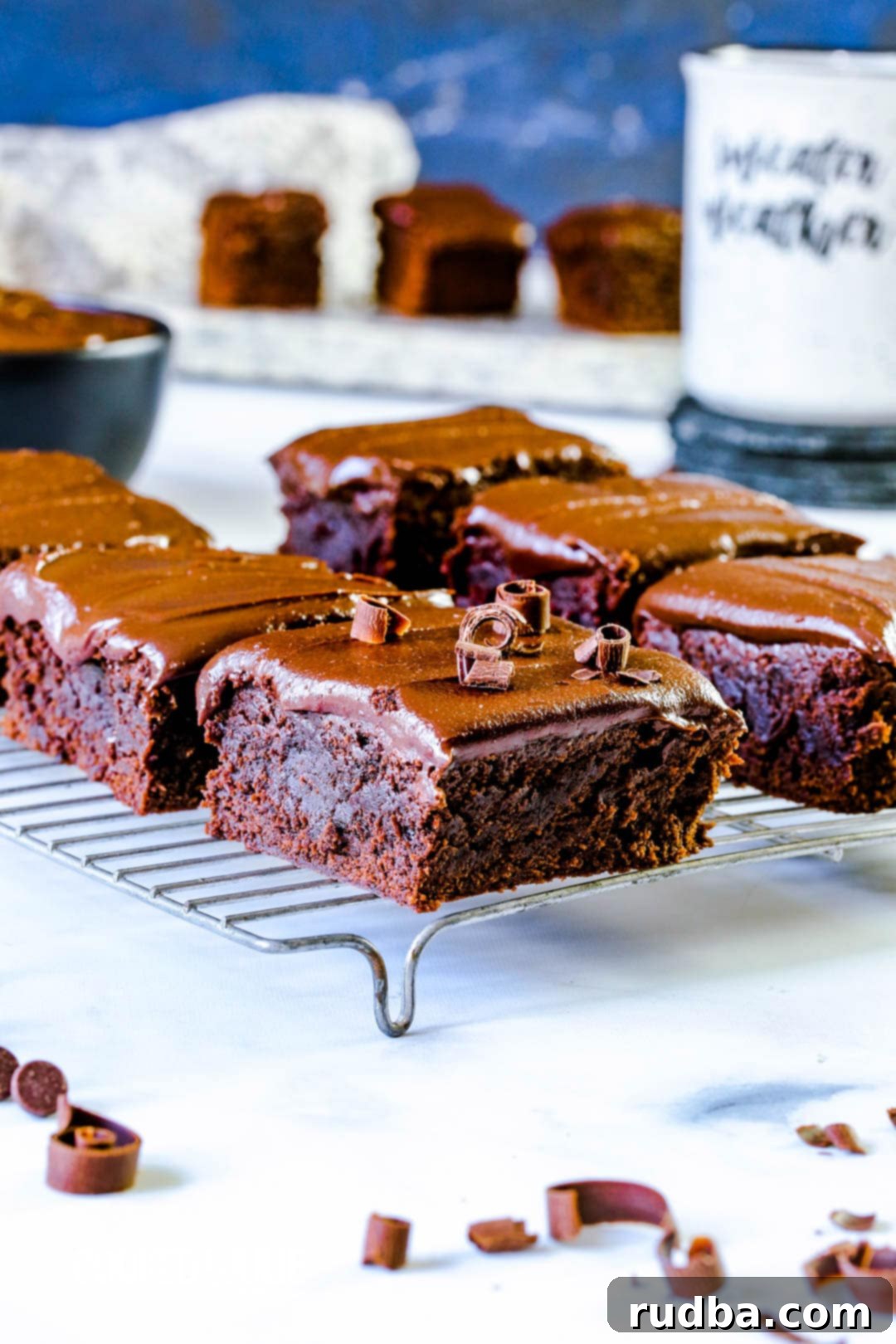 Six perfectly cut chocolate fudge brownies arranged on a wire cooling rack, showcasing their rich color and inviting texture.