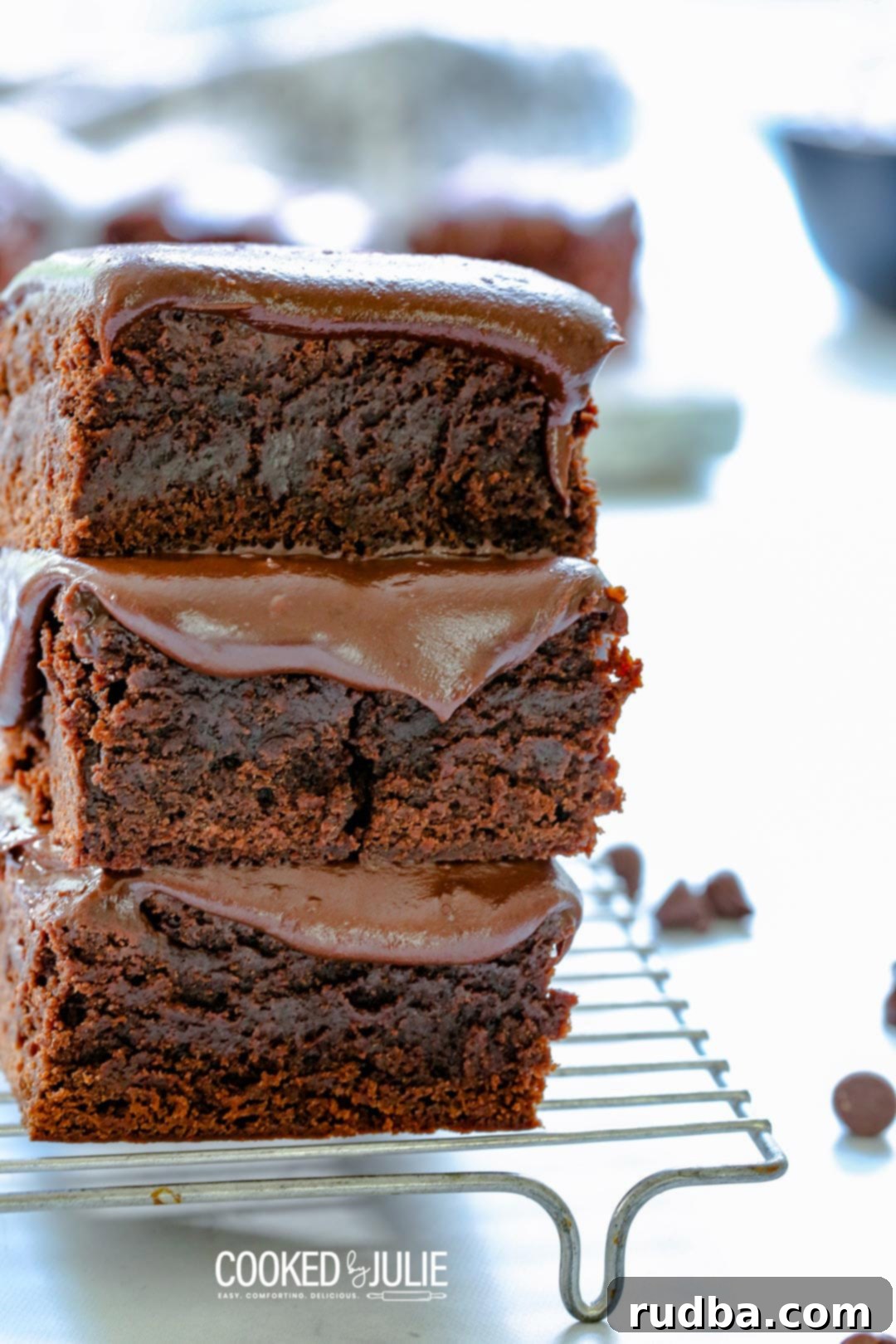 A close-up shot of decadent chocolate fudge brownies cooling on a wire rack, highlighting their glossy, rich surface.