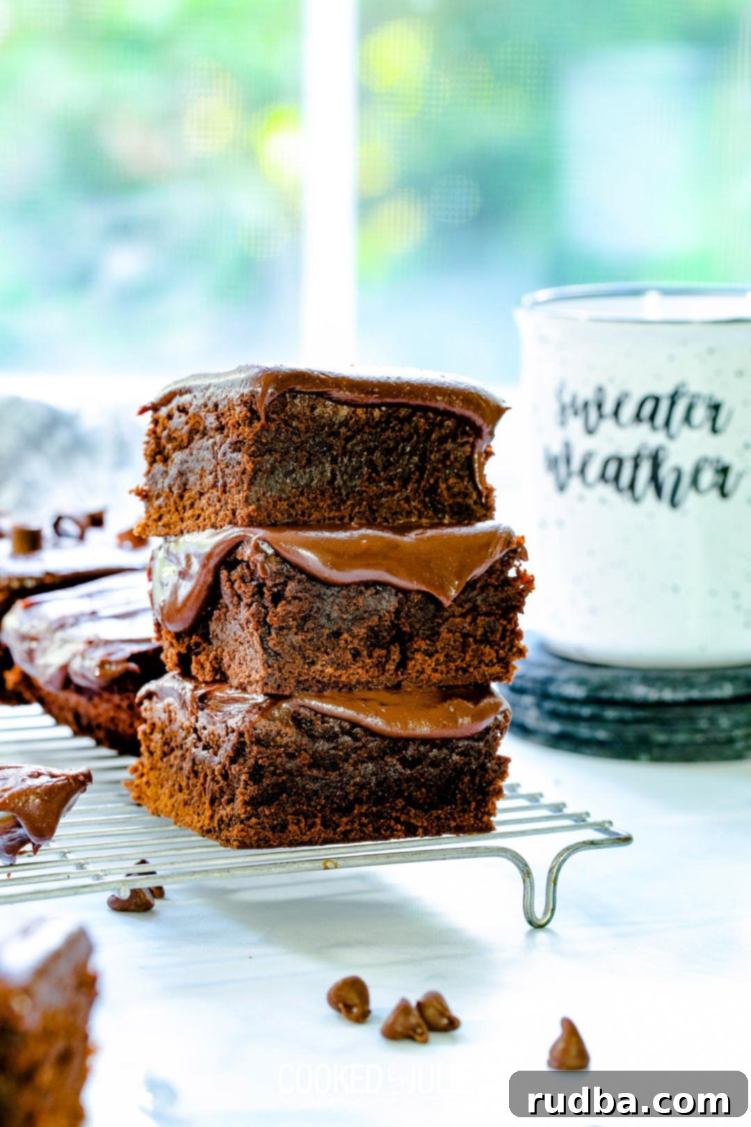 A stack of three irresistibly rich chocolate fudge brownies, showing their thick, fudgy texture and dark color, ready to be enjoyed.