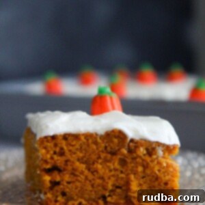 a slice of pumpkin cake with cream cheese frosting up close.