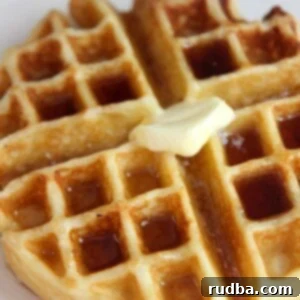 Fluffy Buttermilk Belgian Waffles 5 Close-up of a perfectly cooked buttermilk waffle on a white plate, ready to be served.