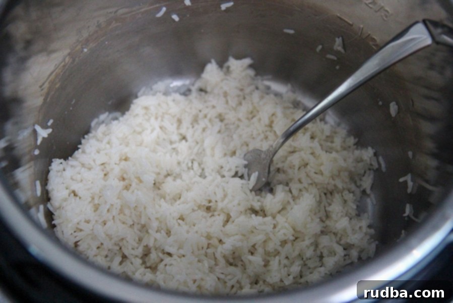 cooked jasmine rice in the instant pot with a fork.