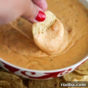 Creamy Instant Pot Queso 5 a chip dipped in a bowl of yellow queso.