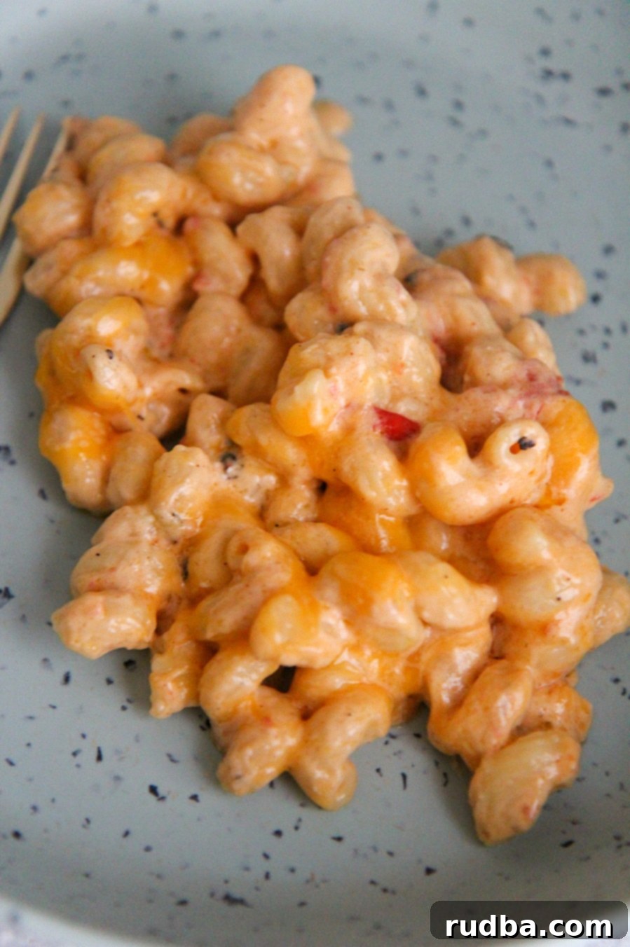 cheesy pasta on a blue plate up close.