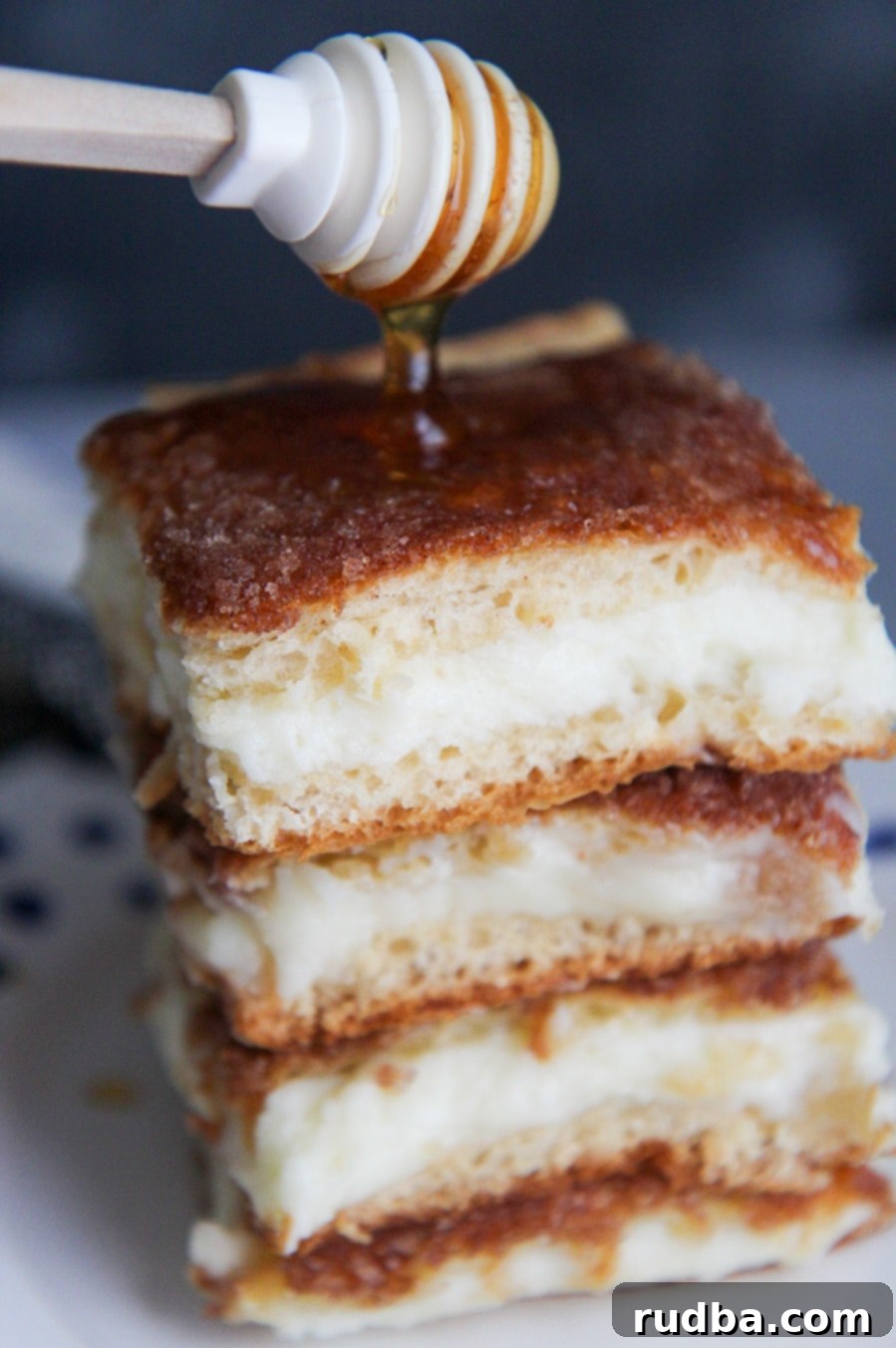 four sopapilla cheesecake bars with drizzled honey on top. 