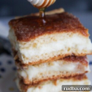 Sopapilla Cheesecake Bars 5 three sopapilla cheesecake bars with drizzled honey on top.