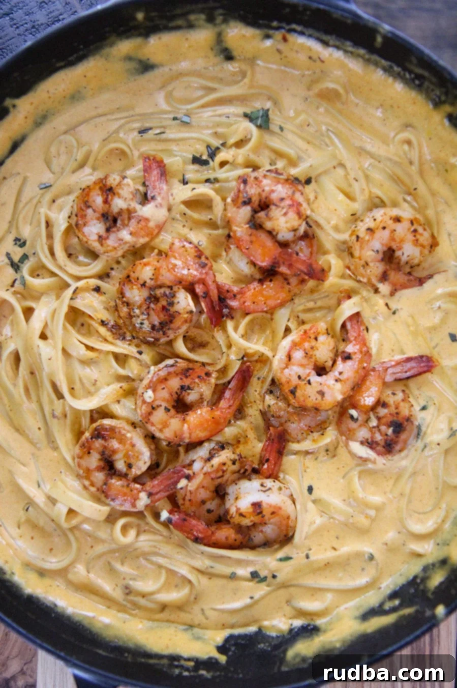 pumpkin fettuccine alfredo with shrimp in a cast iron skillet. 
