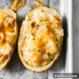 Golden Twice-Baked Treasures 5 twice baked potato with melted yellow cheese and green herbs on top.