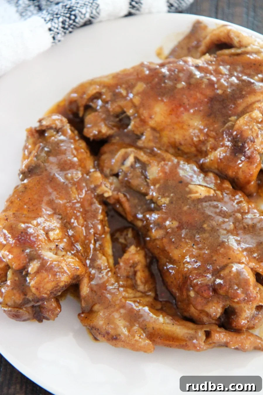 smothered wings on a white plate up close.