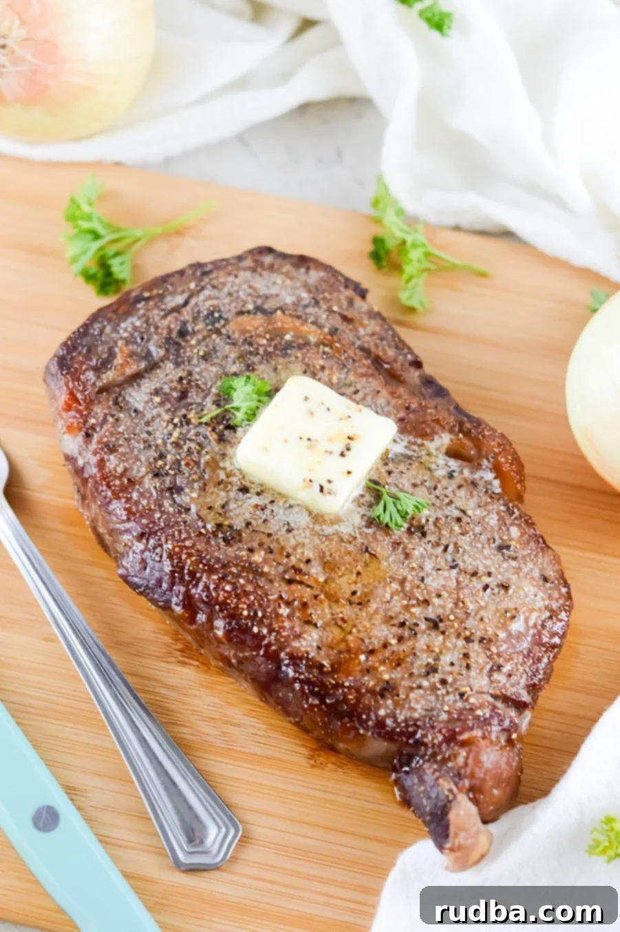 air fryer cooked steak with butter and parsley on top. 