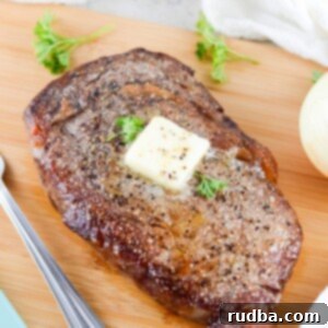 air fryer cooked steak with butter and parsley on top.