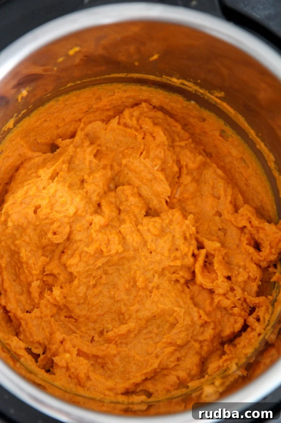 Mashed sweet potatoes cooking directly in the Instant Pot, with some steam visible.