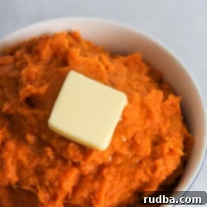 Instant Pot Sweet Potato Mash 4 A small white bowl filled with mashed sweet potatoes and a slice of butter on top.