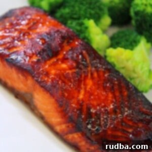 cooked air fryer salmon on a white plate with broccoli