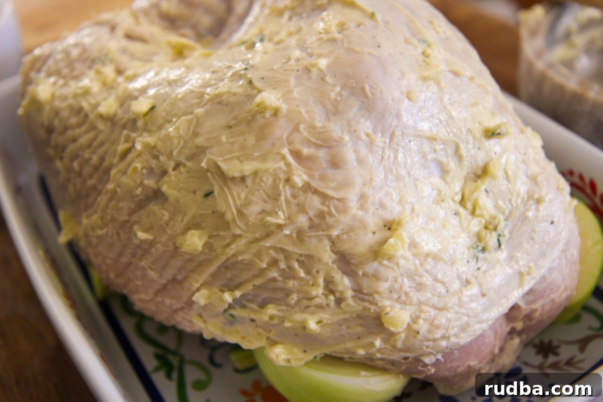 raw turkey breast with butter and garlic all over it. 