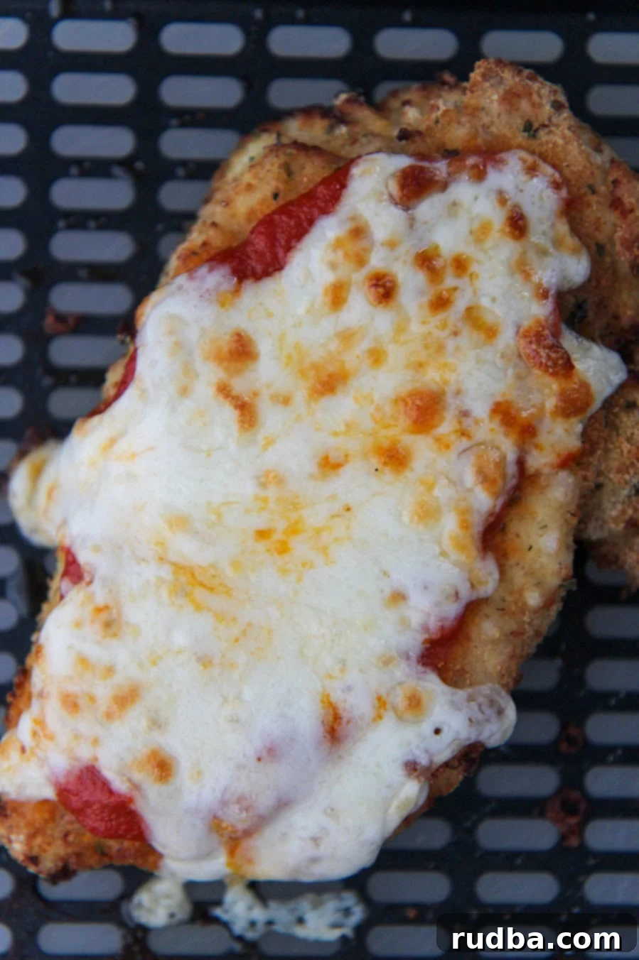 chicken parmesan in the black air fryer basket.