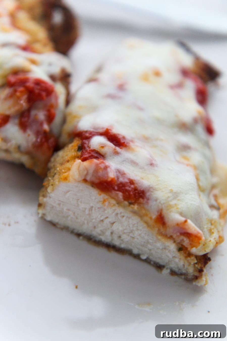 cooked chicken parm sliced in half. 