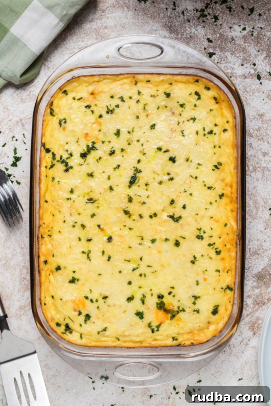Baked pastitsio in a glass baking dish with chopped parsley on top. 