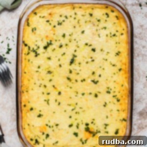 Golden Greek Comfort Bake 7 Baked pastitsio in a glass baking dish with chopped parsley on top.