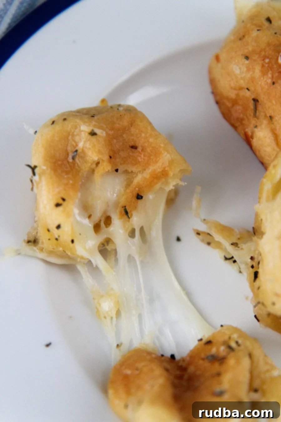 a cheese roll cut in half with mozzarella cheese oozing out. 