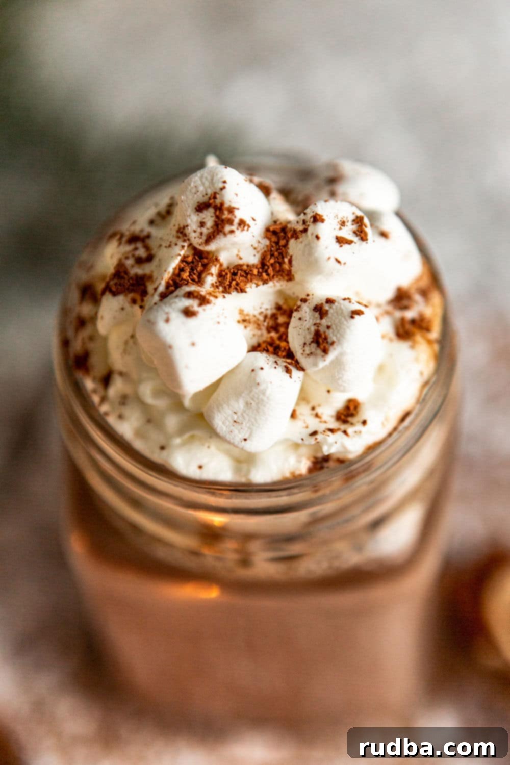 Close-up of creamy hot chocolate topped with a generous amount of mini marshmallows, showcasing its inviting texture.
