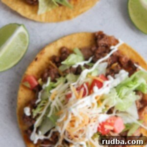beef tostadas up close with two lime wedges.