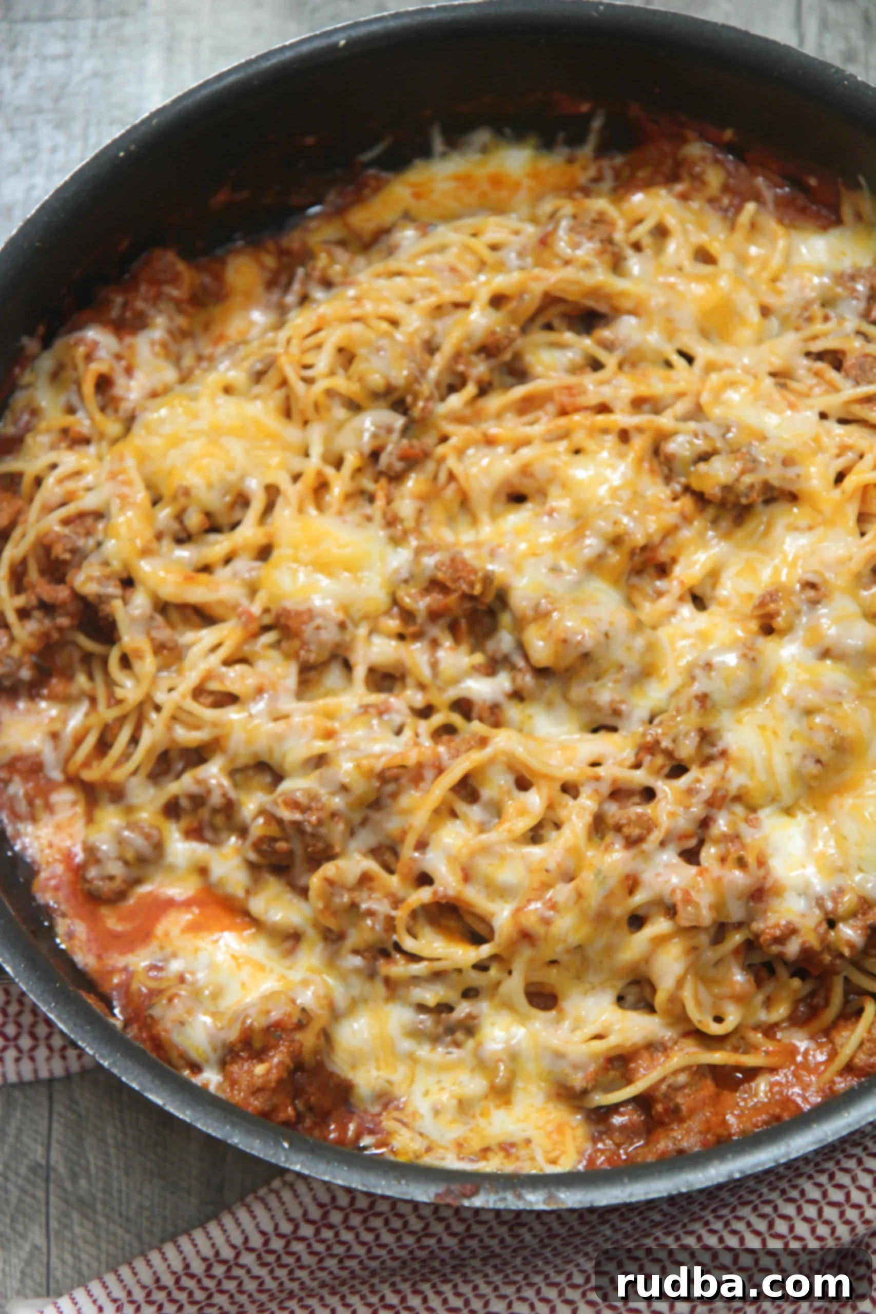 A large bowl of easy cheesy taco spaghetti, garnished with fresh lime, perfect for a cold night or a family dinner.