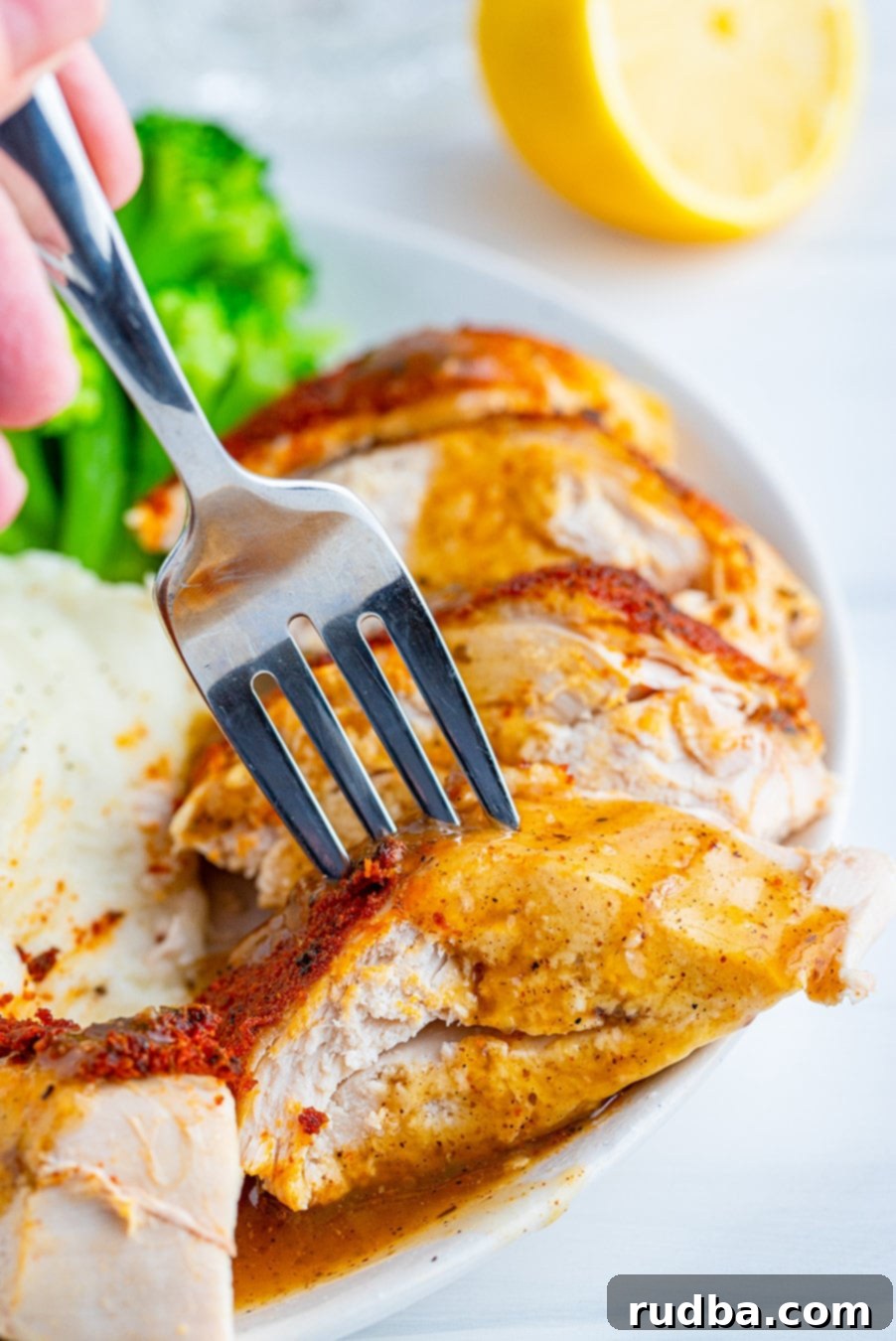 sliced chicken breast with a fork and gravy.