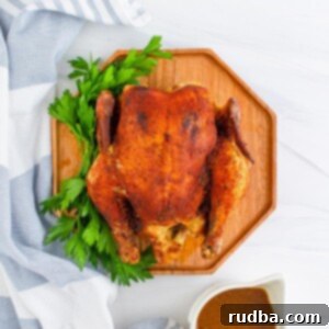 Melt-In-Your-Mouth Slow Cooker Chicken 5 cooked whole chicken on a cutting board with gravy on the side.