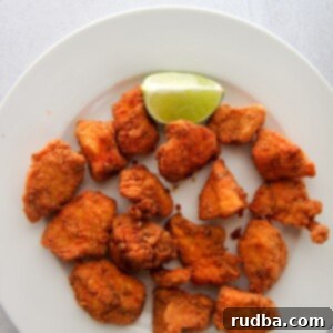 chicharron de pollo aka chicken bites on a white plate with a lime wedge.