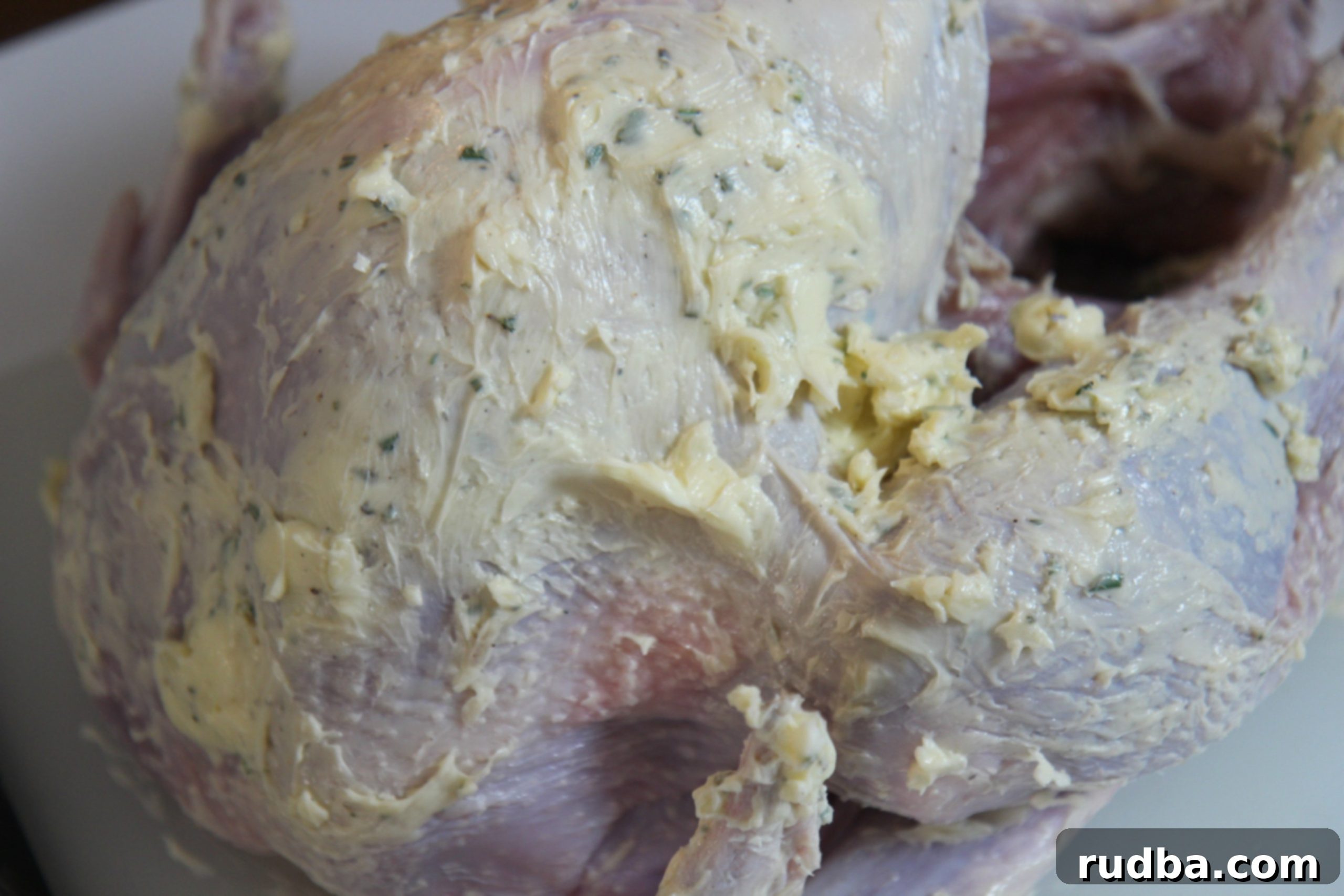 Rub the garlic and herb butter mixture over the raw turkey for a moist and flavorful roasted turkey.