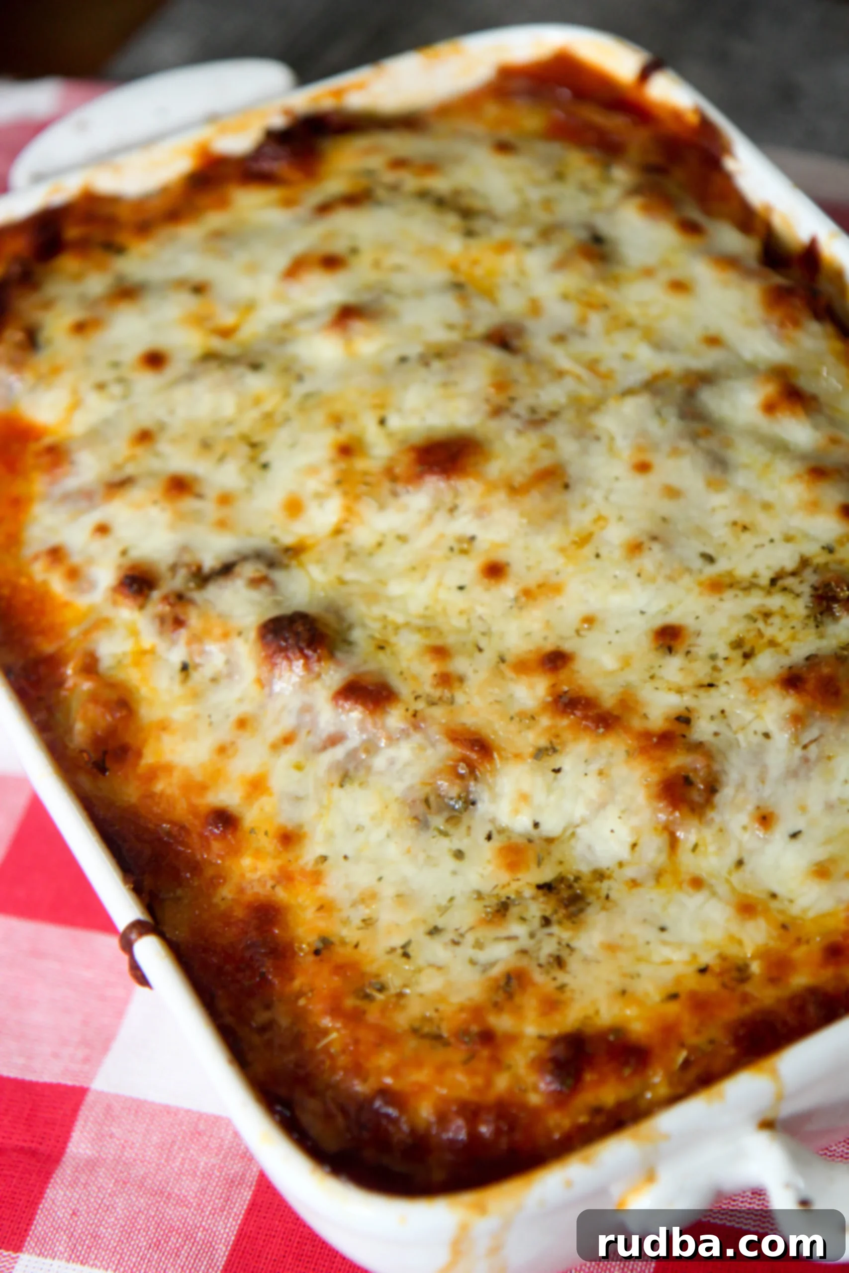 A cheesy, low-carb cabbage lasagna in a white baking dish, ready to be served