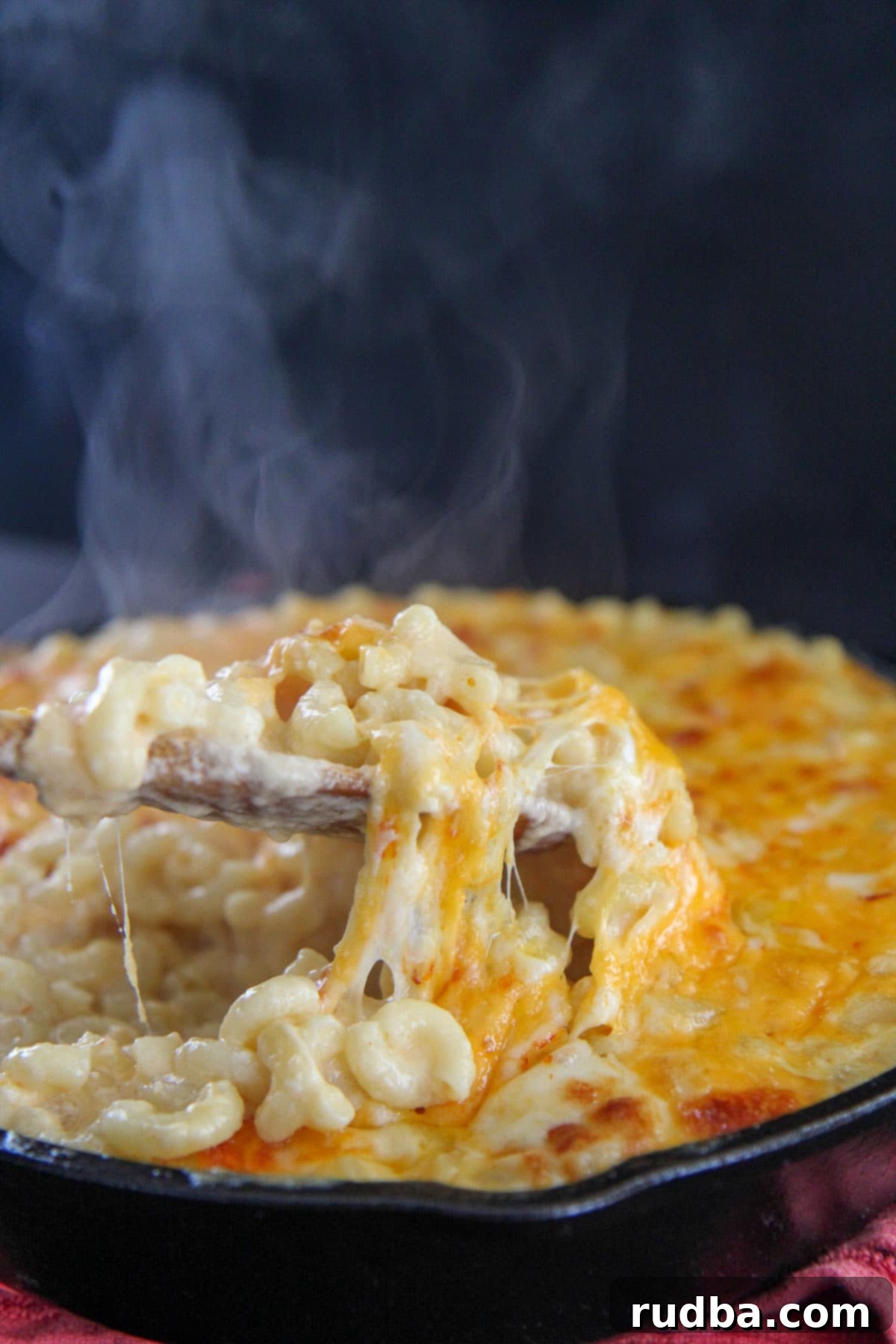 a spoonful of mac and cheese with steam in the background 